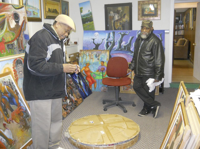 Artists Isaac Pierre (left front) and Fritz Ducheine preparing the artworks