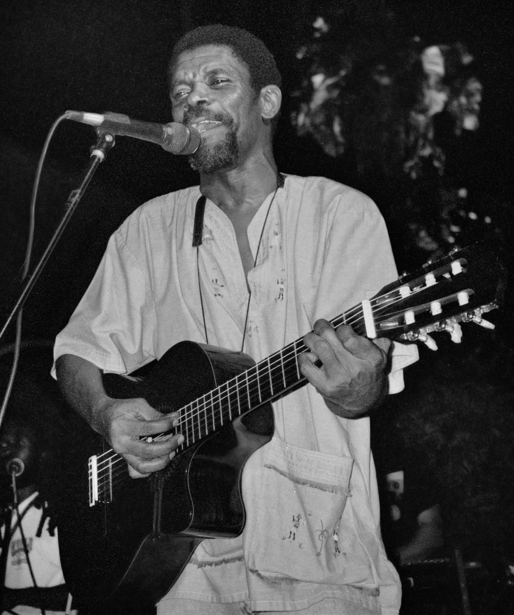 Manno Charlemagne playing the guitar while singing.