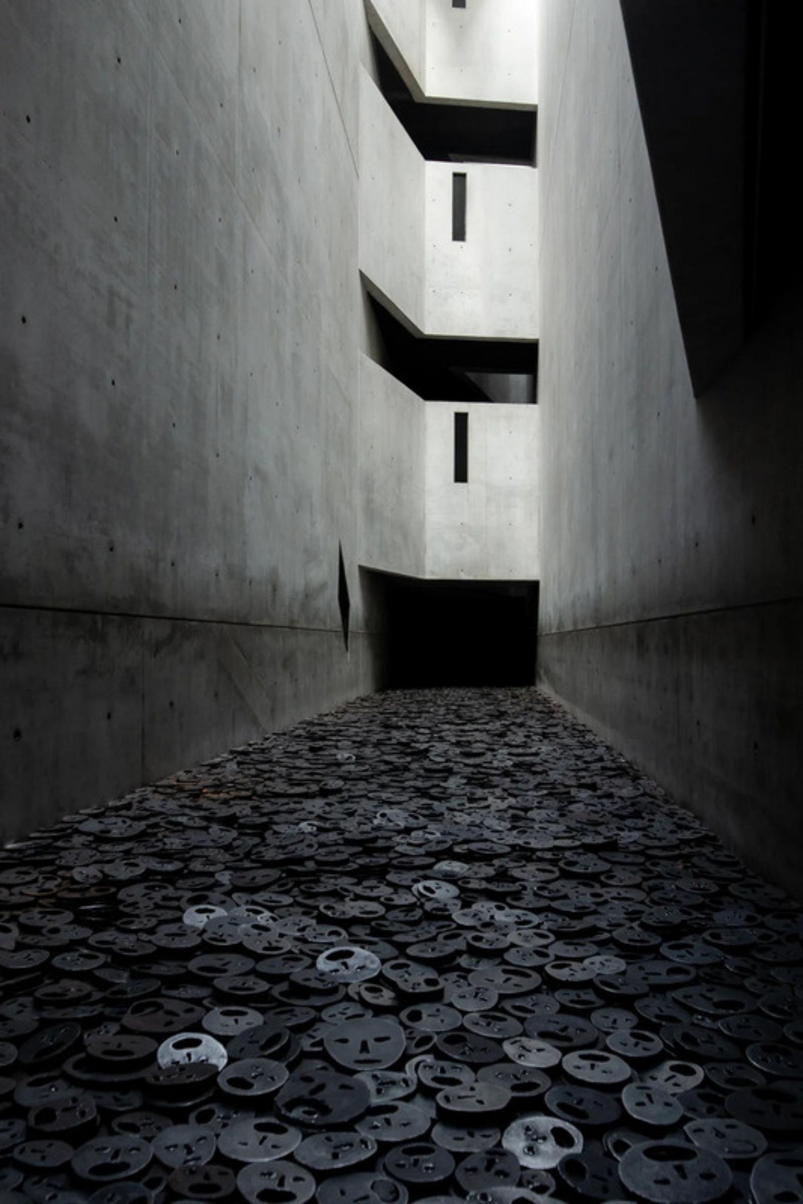 Metal faces fill the floor of the “Fallen Leaves” exhibition room at the Jewish Museum, in Berlin.